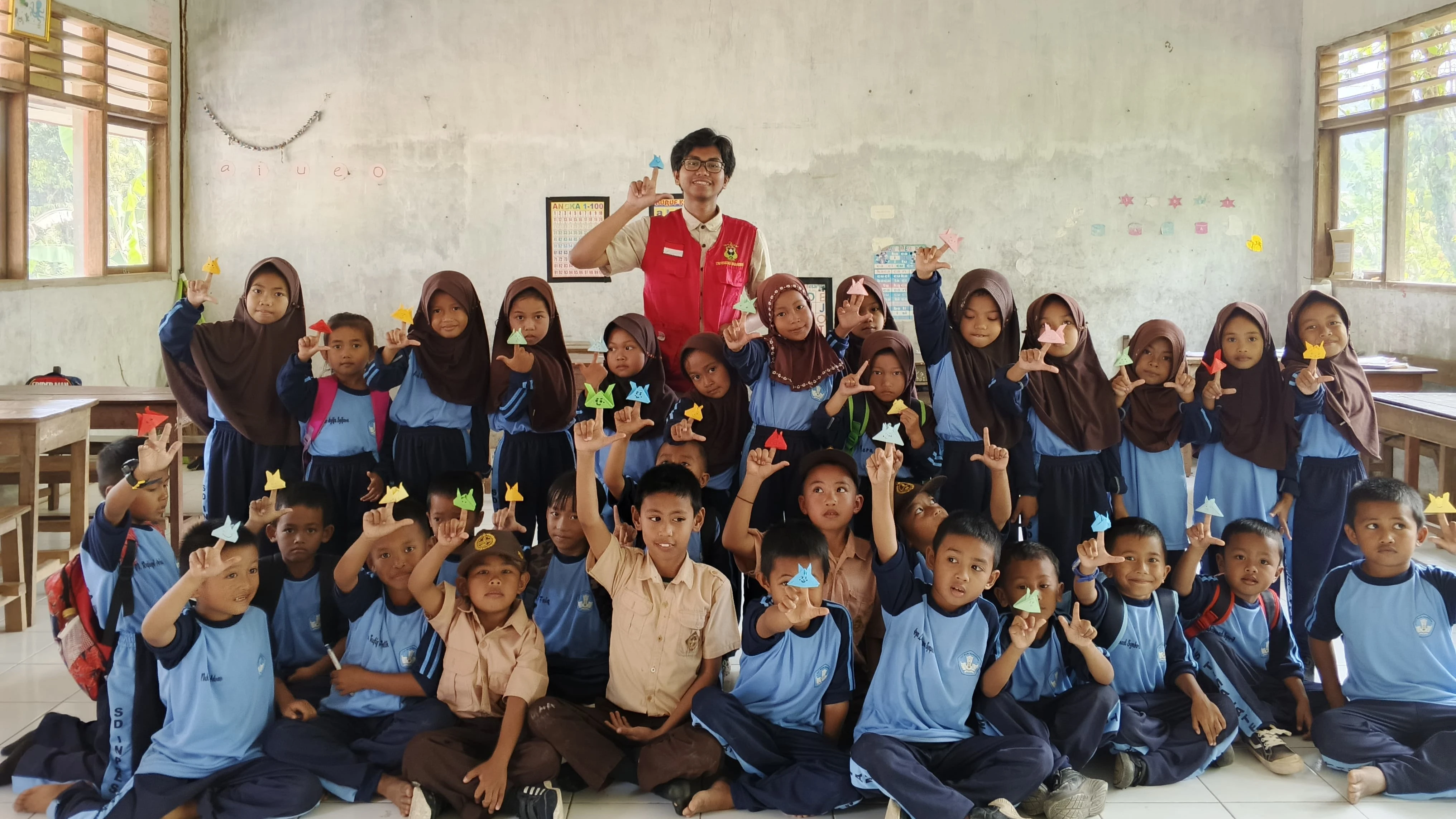 
Sinergi antara buku dan kreativitas! Anak-anak di SDI Pannyikokang, Gowa, dengan bangga memamerkan hasil karya origami bintang mereka, didampingi oleh kakak-kakak dari KKN Tematik Literasi UNHAS. Kredit: KKN UNHAS.